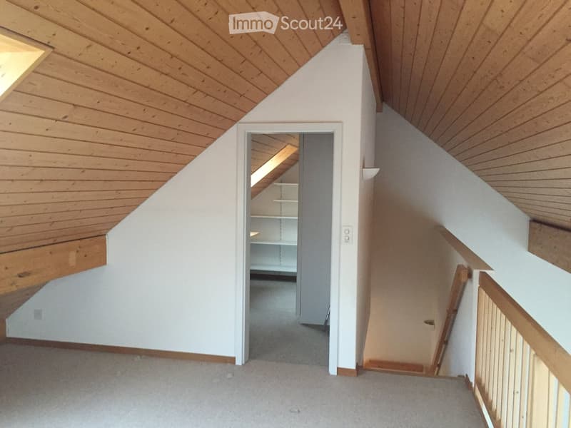 Empty hallway with wooden ceiling, white walls, carpeted floor, and a staircase leading upwards.