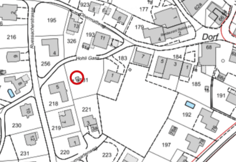 Floor plan of a residential area showing multiple buildings and numbered plots, with a highlighted plot marked with a red circle.