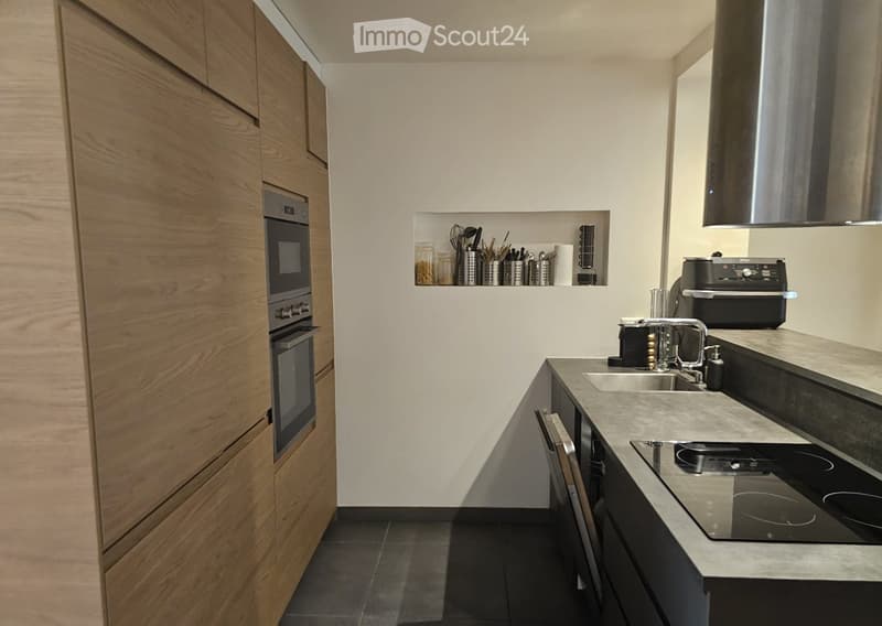 Modern kitchen with wooden cabinets, stainless steel appliances, and a sleek countertop.