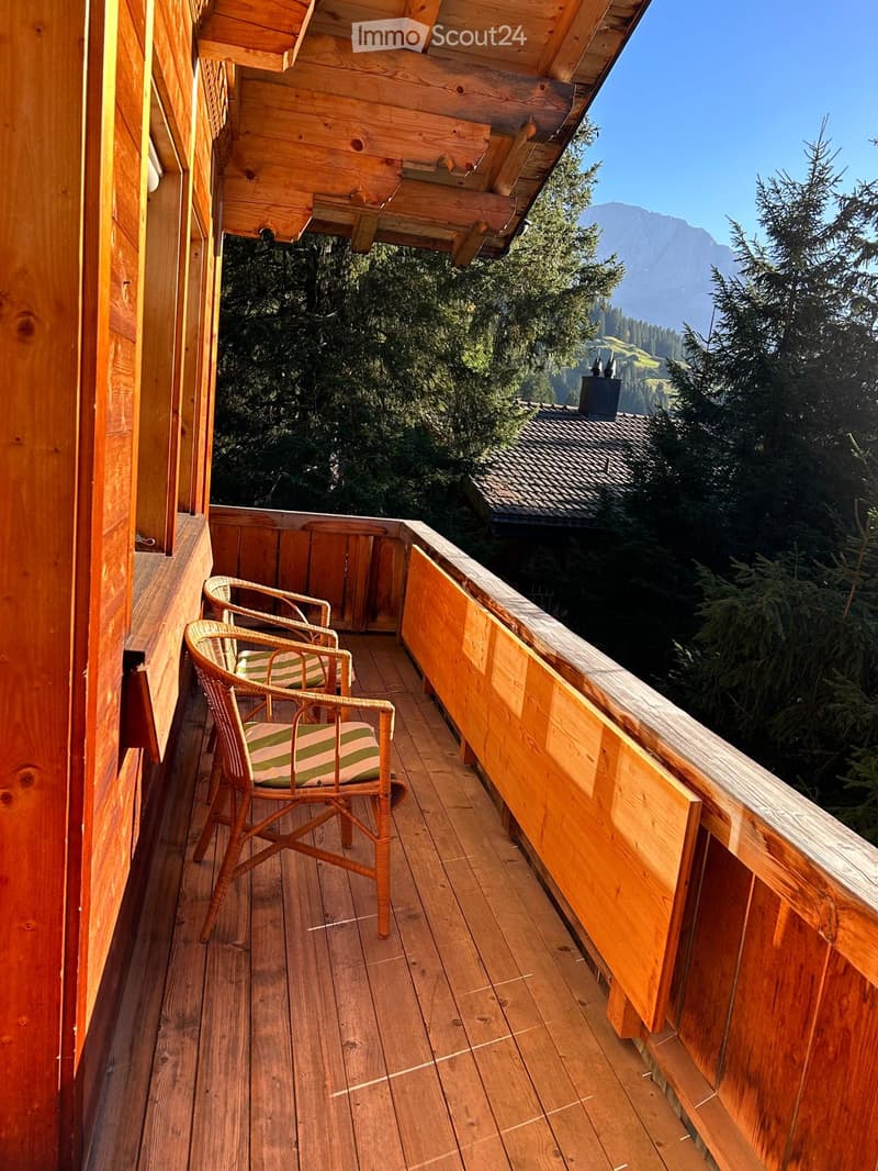 Wooden balcony, wooden railing, two chairs, beautiful mountain view