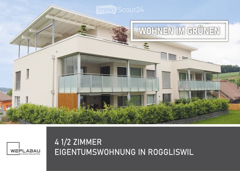 Modern two-story house with light beige exterior, large glass balconies, and a flat roof terrace. The house features contemporary design with clean lines and large windows, surrounded by well-maintained greenery.