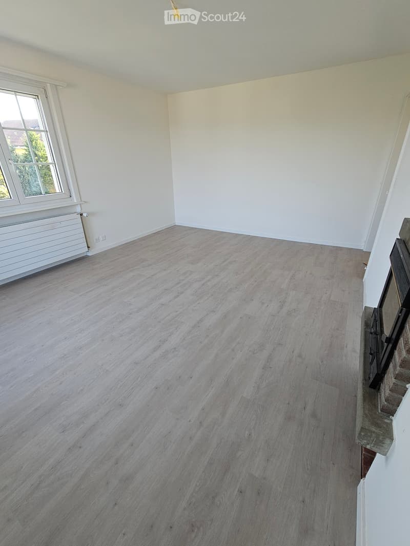 Empty room with light wooden flooring, white walls, and a window with white frame. No furniture or equipment visible.