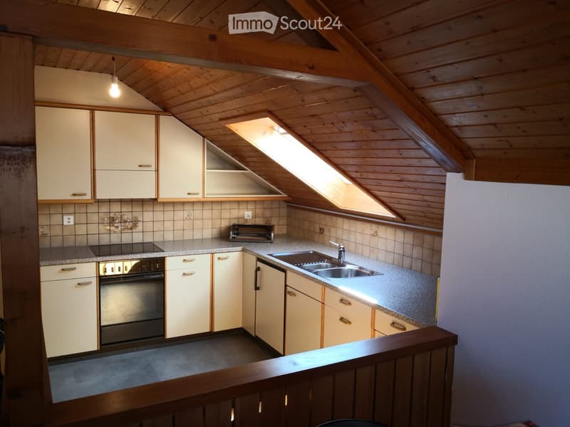 Cozy kitchen with wooden beams, white cabinets, granite countertops, and stainless steel appliances.