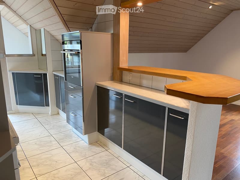 Modern kitchen with stainless steel appliances, wooden countertops, and white cabinets.