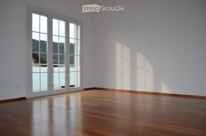 empty room, wooden floor, white walls, large glass doors leading to balcony, power outlet, view of mountains