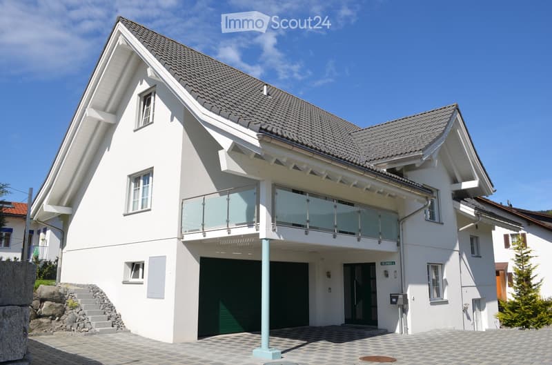 modern white house, gray roof, glass balcony, garage, paved driveway