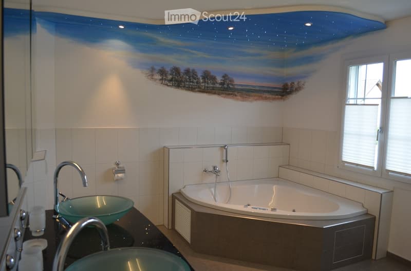 Bathroom with a large bathtub, two sinks, and a window with blinds. The walls are painted white, and the ceiling has a blue sky mural with stars.