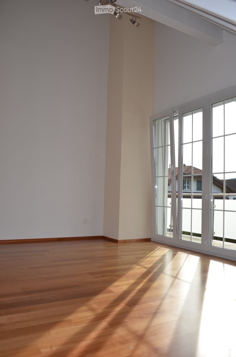 empty room, wooden floor, white walls, large glass doors leading to balcony