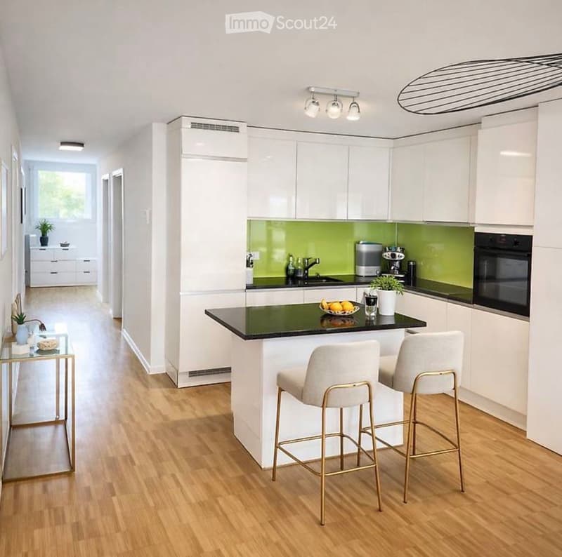 Modern kitchen with white cabinets, green backsplash, island with bar stools, and various appliances including an oven and coffee maker.
