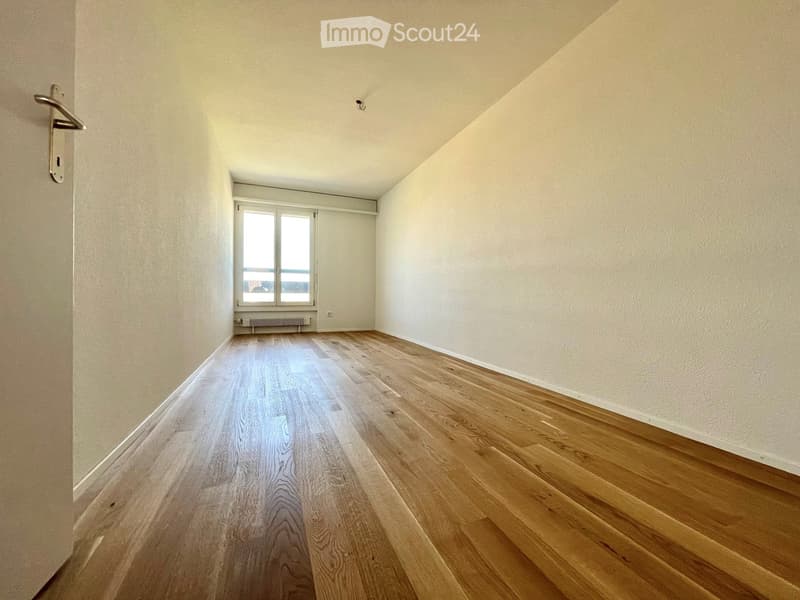 Empty room with wooden flooring, white walls, and a window with blinds. No furniture or equipment present.