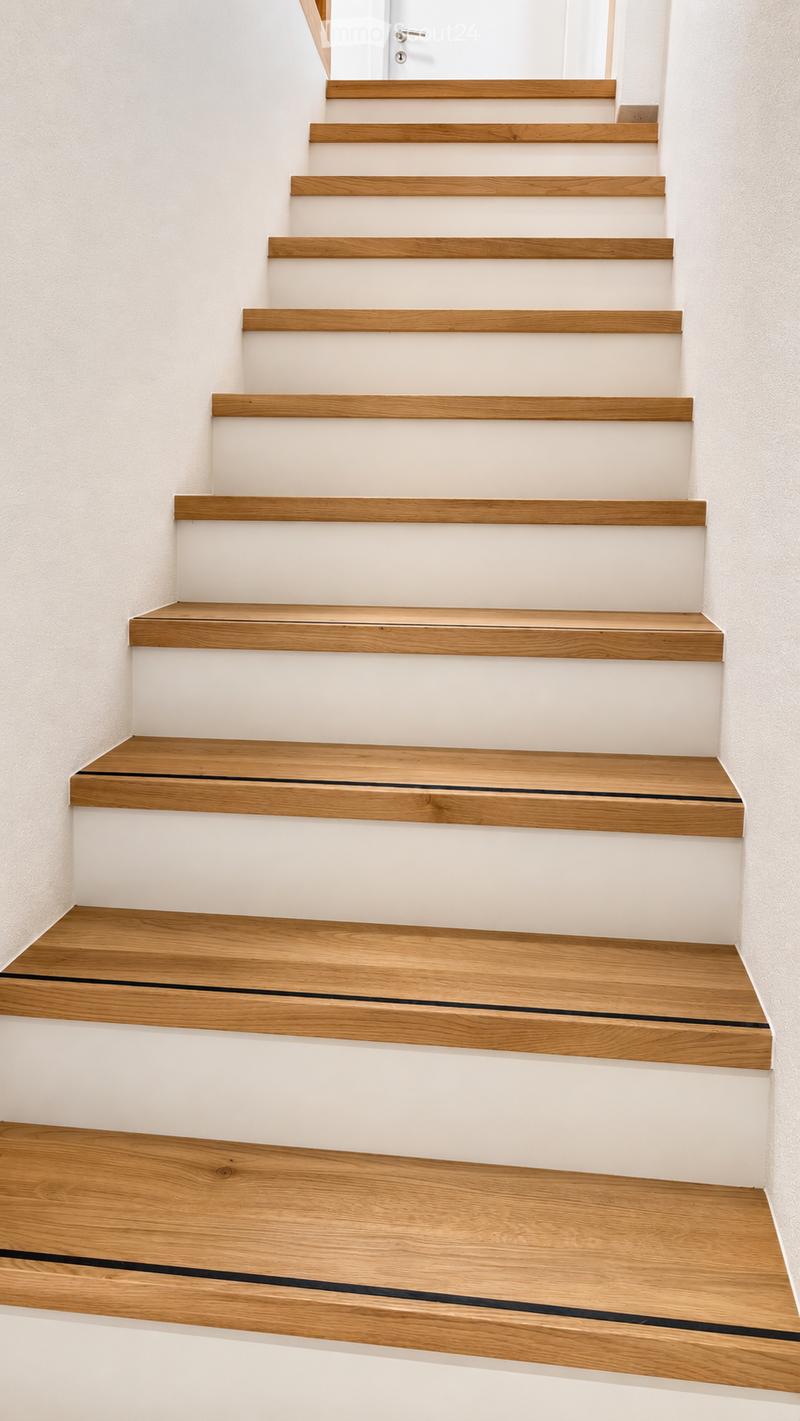 Modern staircase with wooden steps and white risers, featuring a sleek design and minimalistic aesthetic.