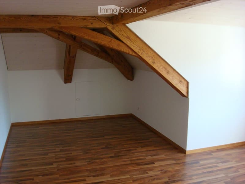 empty room with wooden flooring and wooden beams
