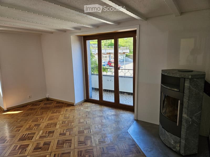 Furnished Room. Bright room with wooden parquet flooring, large sliding glass door leading to a balcony, and a stone fireplace.