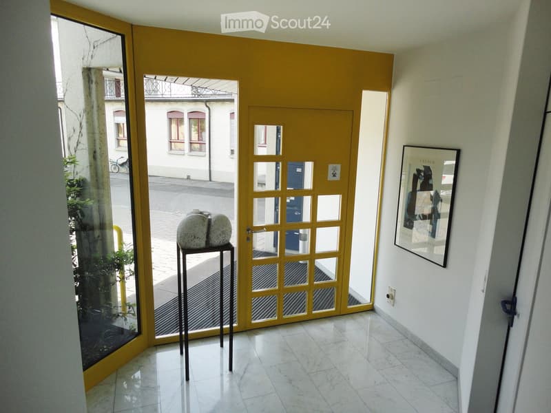 Yellow entrance doors, marble floor, sculpture on a pedestal, window, picture frame on the wall