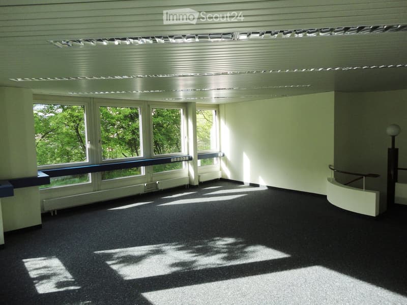 large windows, carpeted floor, metal ceiling, heating units under windows, staircase