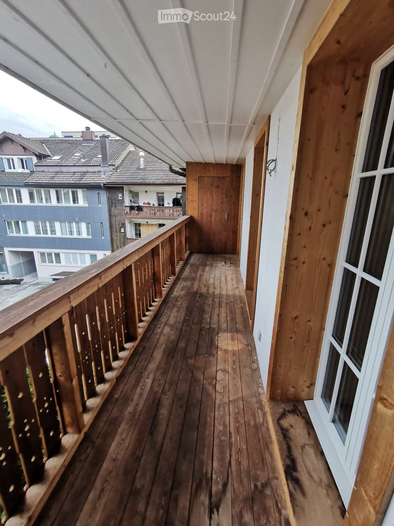 wooden floor, wooden railing, wooden door, white wall, glass window