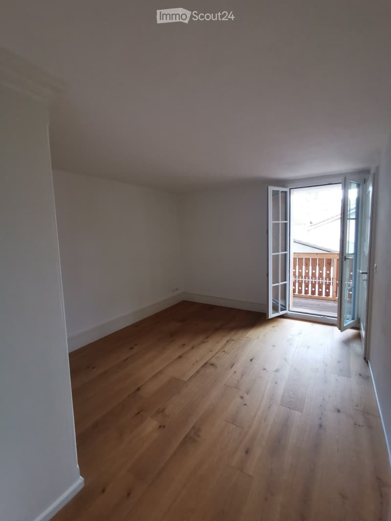 empty room, wooden floor, white walls, open doors to balcony
