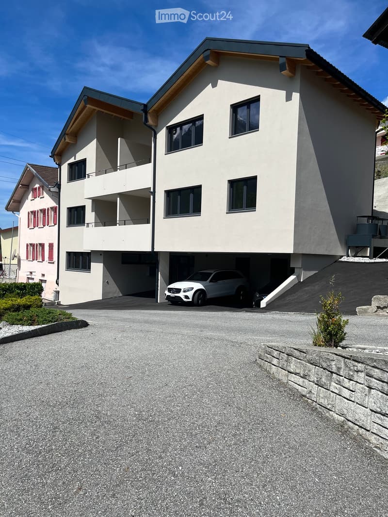 3 story apartment building, white exterior, red shutters, car parked in garage