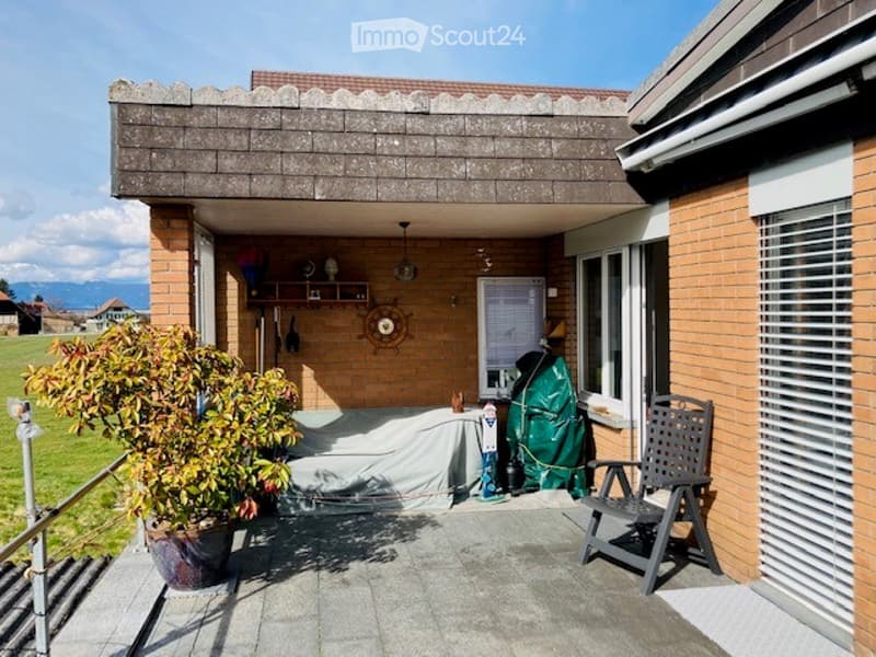 Balcony with brick walls, covered roof, outdoor furniture, and scenic view of the countryside.