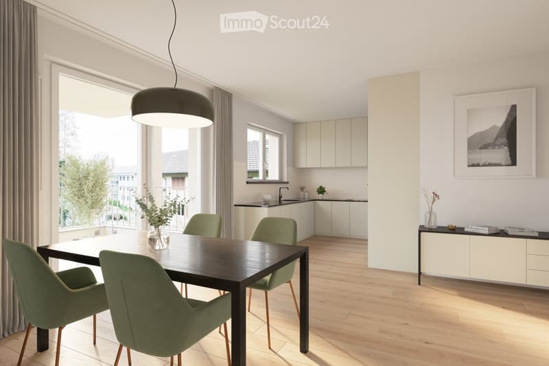 Modern dining area with a dark wooden dining table, four green chairs, a pendant light, and a kitchen area with white cabinets, a sink, and a vase with greenery. A picture frame and books are on a sideboard.