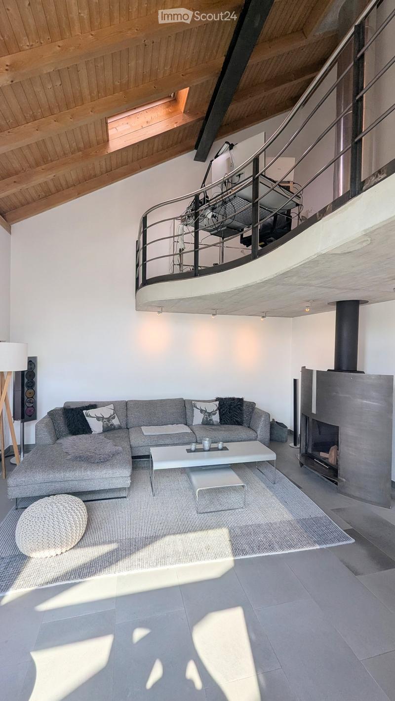 Modern living room with grey sectional sofa, white coffee table, ottoman, floor lamp, and fireplace.