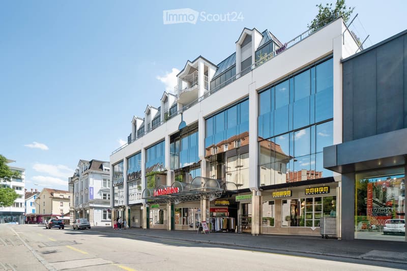 modern building, large windows, shops on ground floor