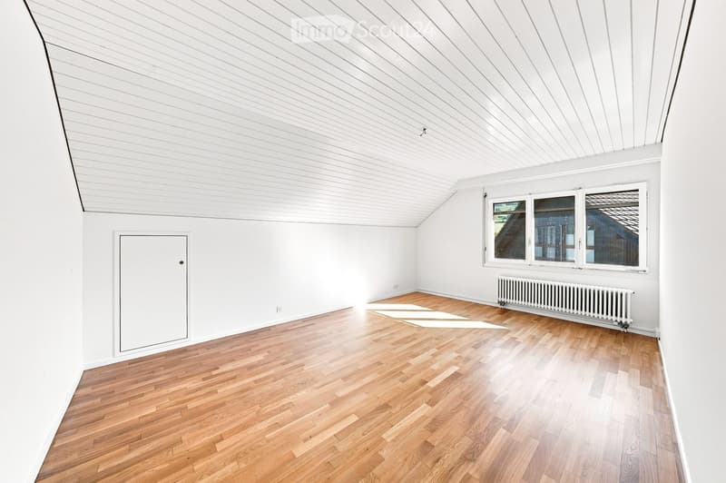 Completely empty room with white walls, wooden floor, and large windows. No furniture or equipment.