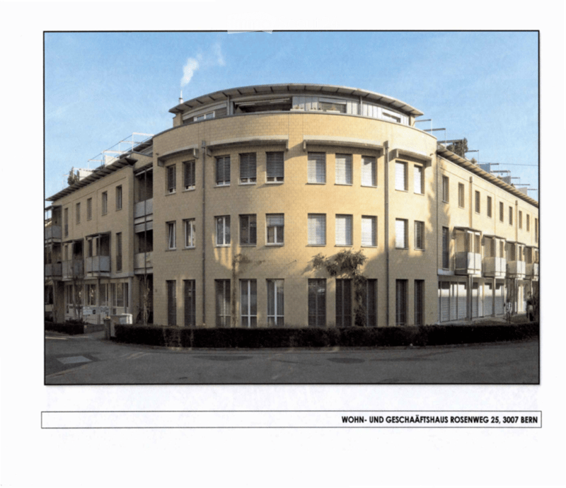 Modern multi-story residential and commercial building with a curved facade, numerous windows, and balconies.