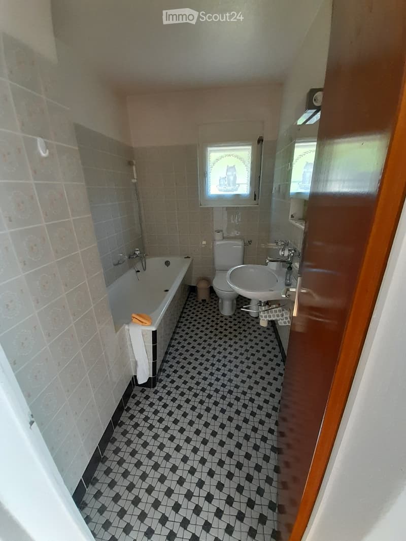 Bathroom with bathtub, toilet, sink, and tiled floor.