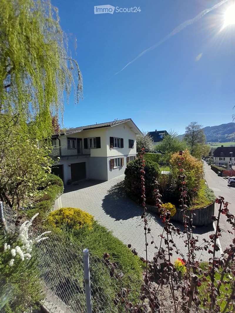 2 story house, white exterior, garage, driveway, garden, balcony