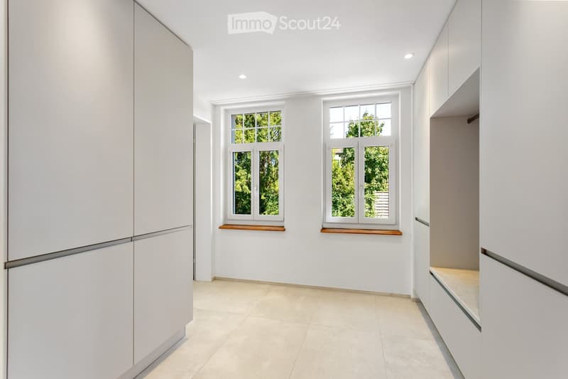 Empty room with white walls, tiled floor, and two windows with wooden sills. No furniture or equipment present.