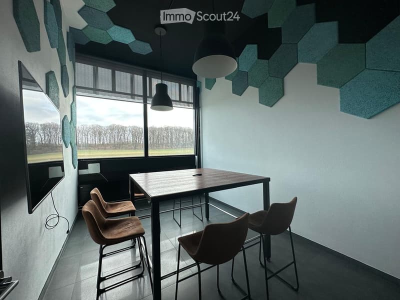 Modern room with large windows, geometric wall panels, and a wooden table with four chairs.