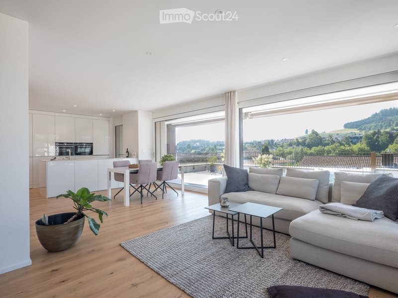 Open floor plan, modern kitchen, large windows, sliding glass doors, hardwood floors, comfortable living room with sofa, dining area, modern furnishings, scenic view