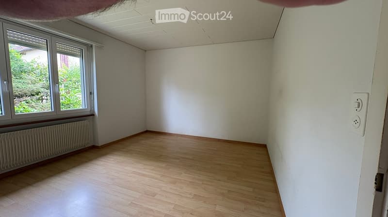 Empty room with wooden flooring, white walls, and a window with blinds. No furniture or equipment is present.