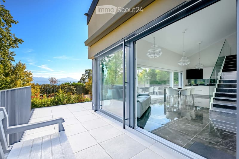 Balcony / Terrace. Modern balcony with large glass doors, white tiled floor, and a view of the outdoors.