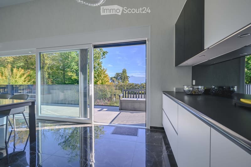 Kitchen. Modern kitchen with marble countertops, white cabinets, and sliding glass doors leading to a balcony with a bench and storage box.