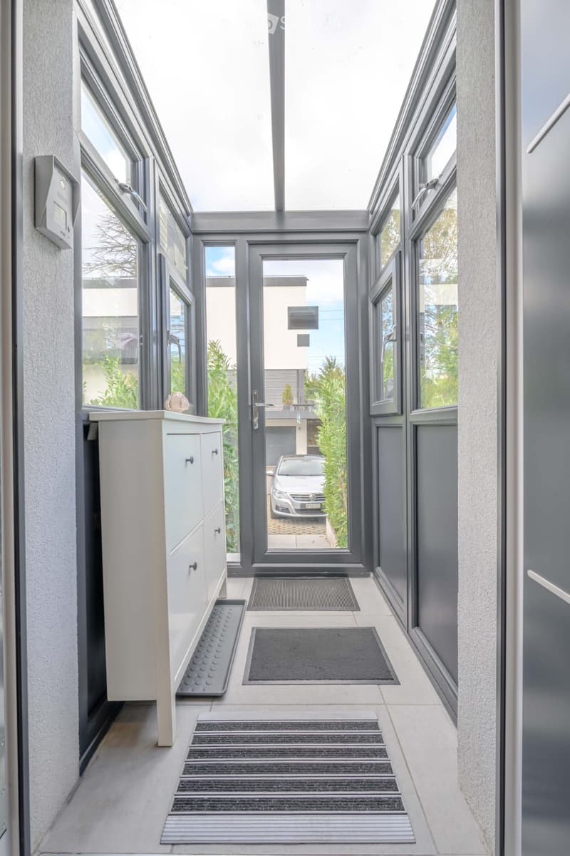 Corridor / Hallway. A corridor with a white cabinet, doormats, and an intercom system.
