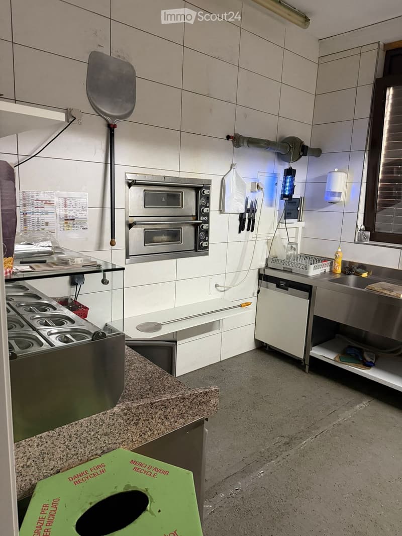 white tile walls, industrial oven, kitchen equipment, stainless steel counter, trash bin