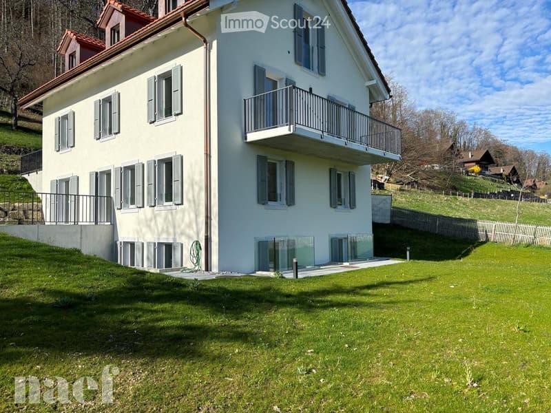 Two-story house with white exterior, multiple windows with shutters, balconies, and a well-maintained lawn.