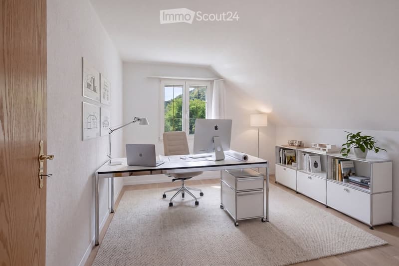 Modern, well-lit home office with a sleek white desk, ergonomic chair, dual monitors, laptop, floor lamp, bookshelf, and potted plant. The room features large windows with a scenic view and a neutral color palette.