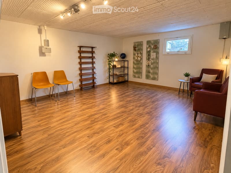 Bright, minimalist room with wooden flooring, two yellow chairs, a red sofa, a small round table, a wooden shelf, and decorative art pieces.