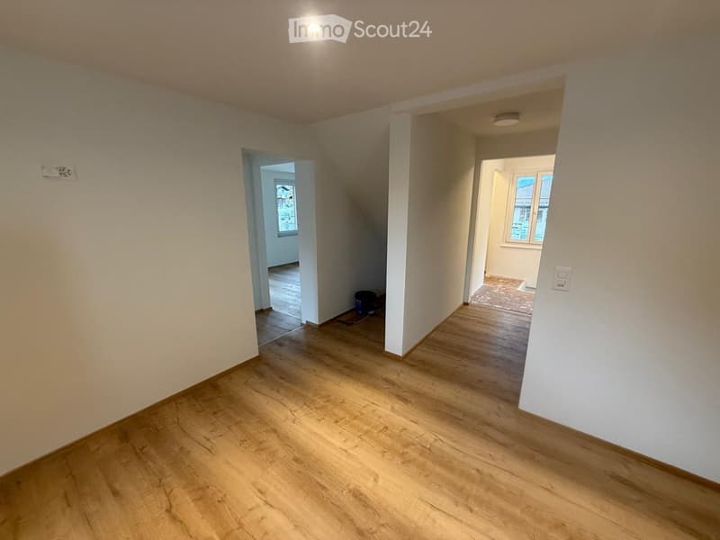 Empty room with hardwood floors, white walls, and windows