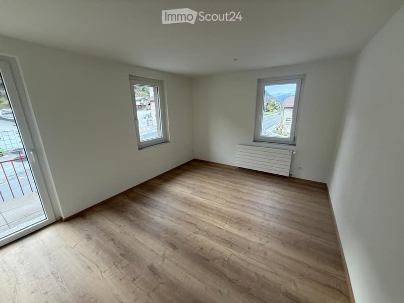 empty room, wooden floors, white walls, two windows, glass door leading to balcony