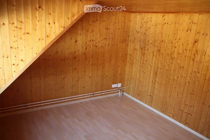 Empty room with wooden walls and floor, no furniture or equipment.
