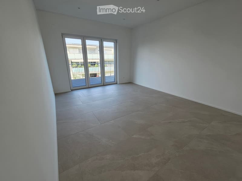 Empty room with tiled flooring and large sliding glass doors leading to a balcony or outdoor area.