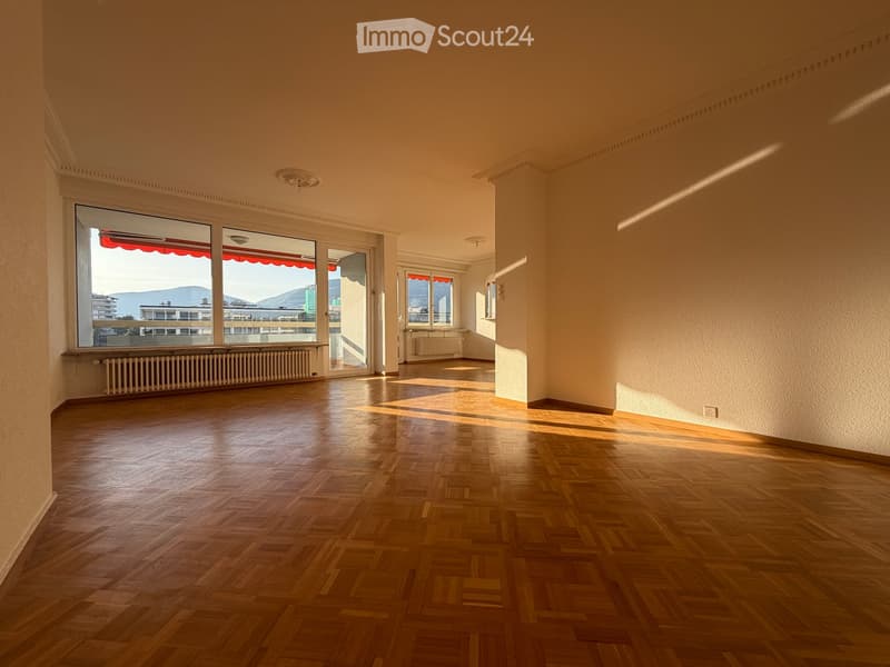 Empty room with wooden flooring, large windows, and natural light. No furniture or equipment present.