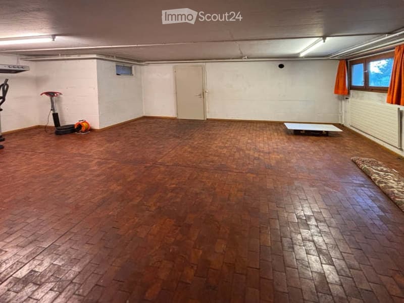 Empty room with wooden flooring, white walls, and a single door. No furniture or equipment present.