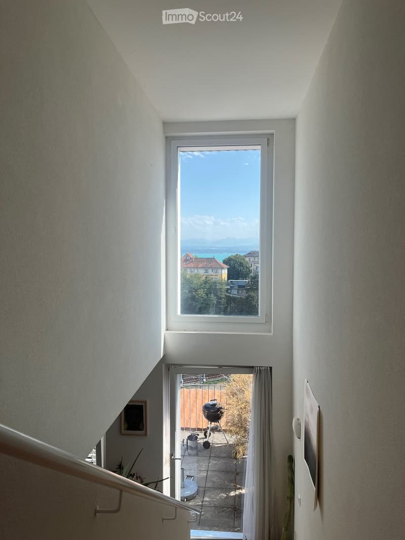 Staircase leading to a balcony with a scenic view of the lake and surrounding area.