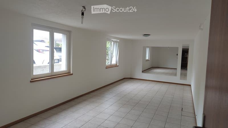 Empty room with tiled floor, white walls, and large windows. No furniture or equipment visible.