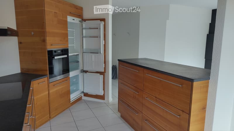 Modern kitchen with wooden cabinets, stainless steel appliances, and a grey countertop.